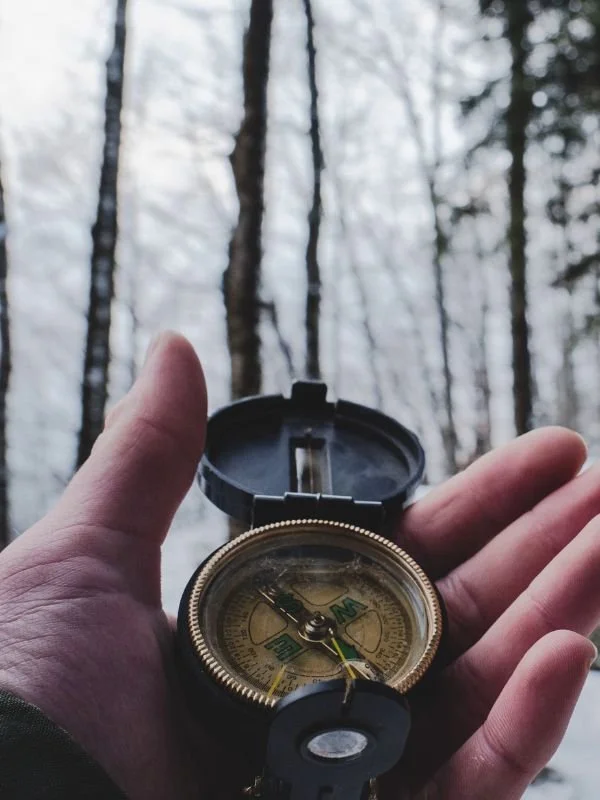 A compass resting on natural stone, finding direction in uncertain terrain
